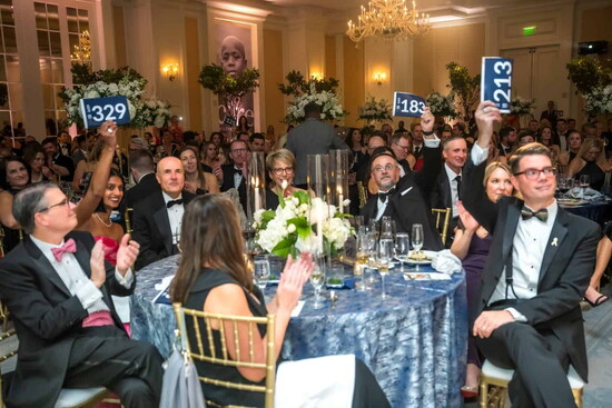 The Novelis sponsor table gets into the spirit of bidding at the Believe Ball - a little friendly competition helped raise $$ for CURE.