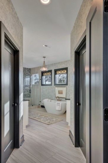 Master bathroom features mixed-metal fixtures and unique tile treatments.