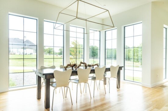 An open concept formal dining area is drenched in warm, natural light, easily accessible 