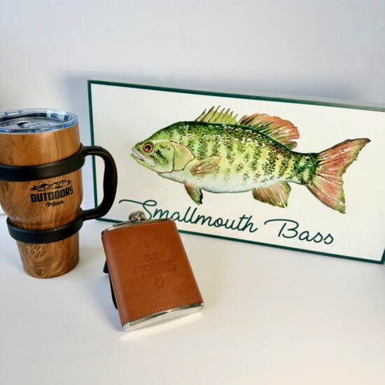 Pavilion Designs – Outdoors Man 32-ounce tumbler; Smallmouth Bass wooden sign; Out Fishing flask.  Threads Boutique Wauconda. $