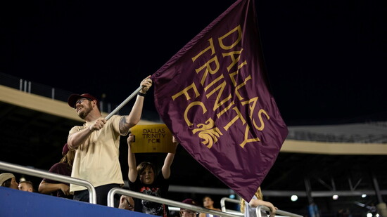 Dallas Trinity FC fan waving their team flag.