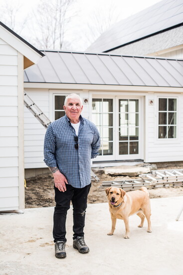 Dan Musolino and his dog Bella at an energy-efficient, custom-built farmhouse nearing completion