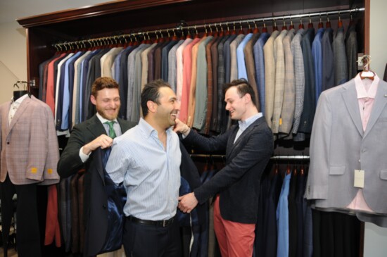 Manoj Daswani tries on a jacket with the help of his co-workers, Daniele Antoniella, left, and  Benjamin Zuk, right. 