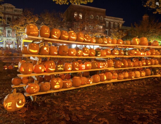 A rack of pumpkins are lit at dusk at the Keene Pumpkin Festival. 