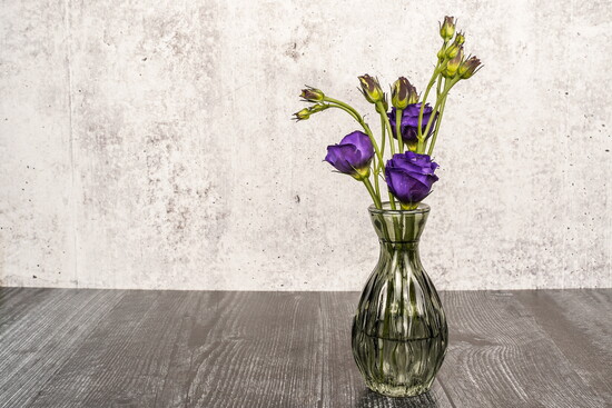 Small bud vase filled with purple lisianthus flowers.
