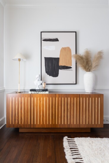 For this young family, new lighting, artwork, and accessories were added to compliment the existing stylish credenza which really brought the room together. 