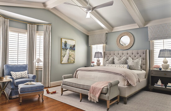 Feminine touches create softness in the primary suite, including a tufted headboard from Vanguard, skirting detail of the chair and the curved arms of the 