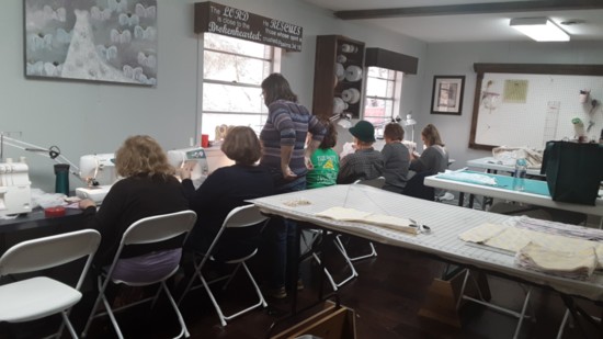 Volunteers gather to sew Memory Gowns.