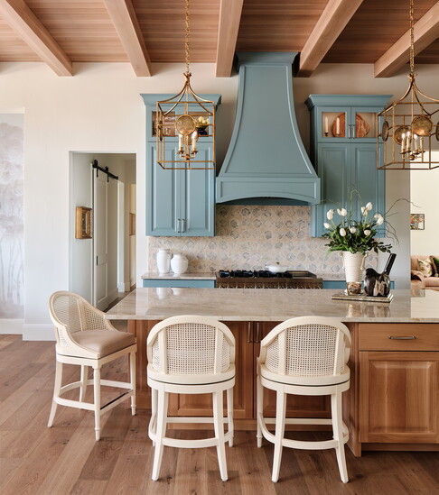 Soft blue cabinetry and warm wood finishes give this Slaughter Design Studio kitchen a relaxed, welcoming character.
