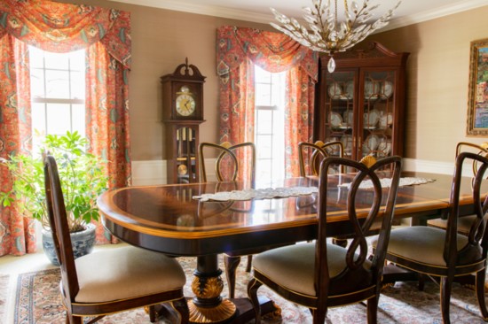 The dining room features silk wallpaper and window treatment fabric by Cowtan & Tout and furniture by Jonathan Charles.
