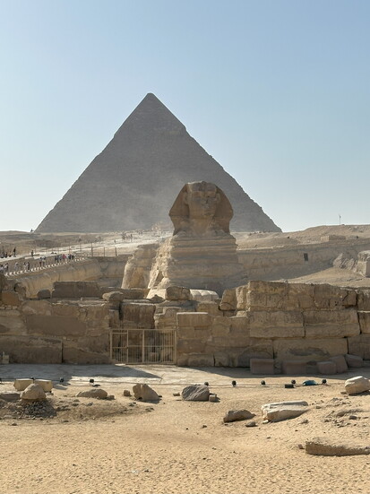 The Great Sphinx (foreground) arises from the desert sands. The Great Pyramid of Gize is shown in the background. (Photo by Susan Karther)