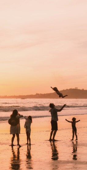A family soars at sunset on Butterfly Beach. Photo by Blake Bronstad, Courtesy of Visit Santa Barbara