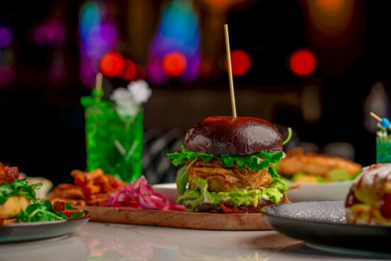 The best-selling Bison King Burger is topped with smoked gouda, avocado, spring mix, crispy onions + garlic aioli