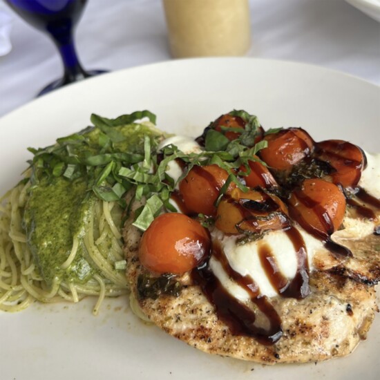 Via Emilia's Pollo Alla Caprese! Grilled chicken breast is topped with buffalo mozzarella, cherry tomatoes, basil, a balsamic reduction.