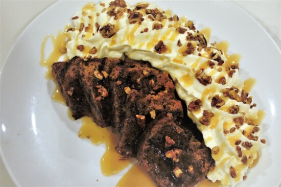 Carmelized banana bread pudding crowned with whipped cream and pecans