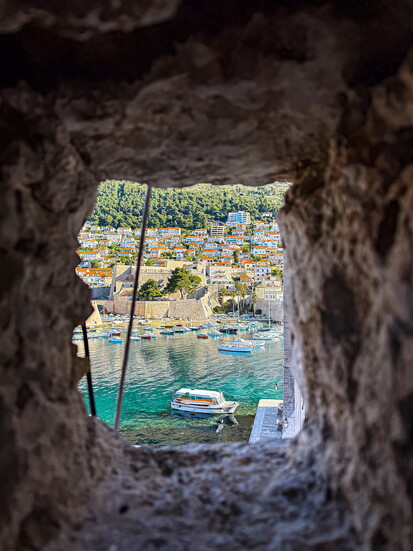 Throught the battlements; an old cannon position reveals the awaitign bay beyond the wall.