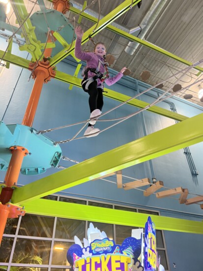 Charlotte Slowinski climbing the  Carabiners ropes course! 