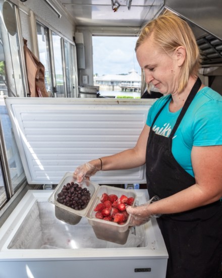 Jackie Martinez shows off the freezer used to store frozen berries.