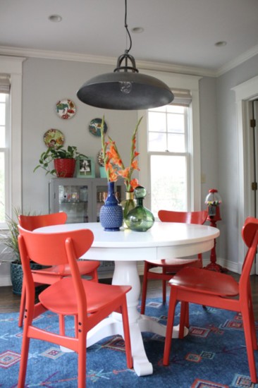 he white pedestal table, red chairs, and tin pendant were already in place. Adding vases, a printed rug and avintage gumball machine brought this room to life. 