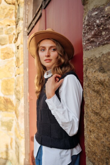 The Hunt: Seasonless chambray shorts, cable knit navy vest over a crisp white button shirt, felt fedora with ribbon detail, gold “Race Day” necklace