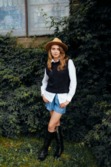 The Hunt: Seasonless chambray shorts, cable knit navy vest over a crisp white button shirt, felt fedora with ribbon detail, gold “Race Day” necklace