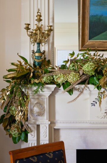 Mixing old (antique marble and gold candelabra) with new artificial greenery.