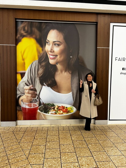 Elaine Espinola beside an advertisement featuring her at Fair Oaks Mall.