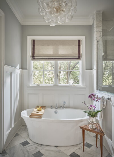 ABOVE: The only change Matthews made to the primary bath was a clear, swirled glass chandelier from Visual Comfort.