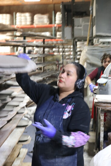 Round plates of fresh clay are then set out to dry before hitting the kiln