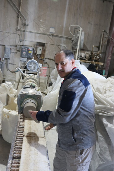Greg Goodman handles a fresh plug of cklay that wikll then be sliced into thick disks