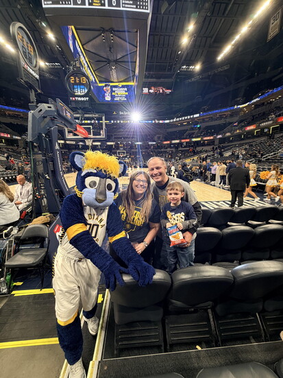Stephanie with her husband DJ and son Adam at his first basketball game which had been rescheduled from 2025 during Stephanie's treatment.