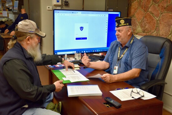 American Legion Post 88 Service Officer Carl Ellison works with a veteran applying for benefits at Post 88 in Norman.