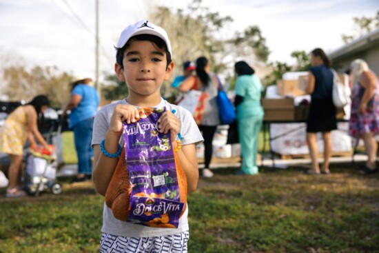  Holding on to oranges at a mobile pantry at Awaken Church in North Port.