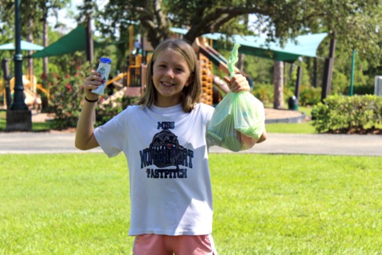 Ashlyn shows her bag of kid-friendly, healthy food she received from All Faith’s BackPack Program.