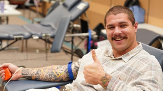 Healer Cole McCutchen donates blood during Our Blood Institute's visit to Norman Regional’s Education Center.