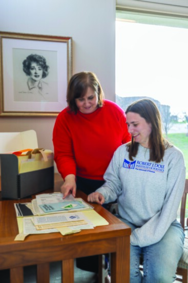 Institute archivist Sarah Gard goes over materials for the exhibit with Alexandra Haggar 