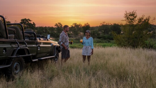 A couple on safari relax at sunset in Kruger National Park in South Africa.