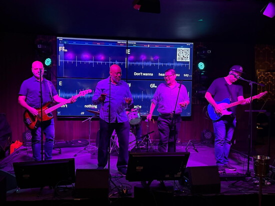 The Carters’ Keller Williams colleagues Marcus Howell and Manny Recinos sing karaoke with a live band at a benefit event at Roaring Social (101 W. Ponce de Leon