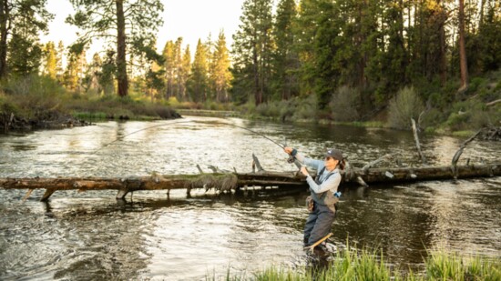 Wild Women of the Water member Liz Jones catches a large Brook Trout wading in the Deschutes River near the Deschutes River Trail. 