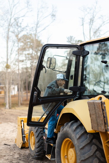 Pa climbing into the backhoe