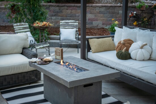 A fire pit adds lovely fall ambiance to this comfortable outdoor setting. S'mores please!