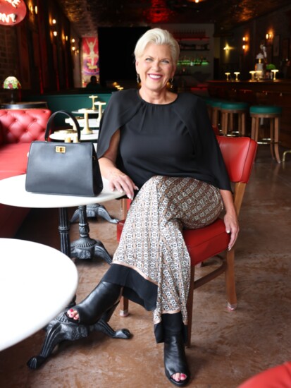 Patterned satin wide leg pant Black blouse with cape detail Structured black thin strap satchel with turn round look