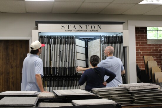 Luke Merriam and Gavin Sievenpiper help a customer make flooring selections.