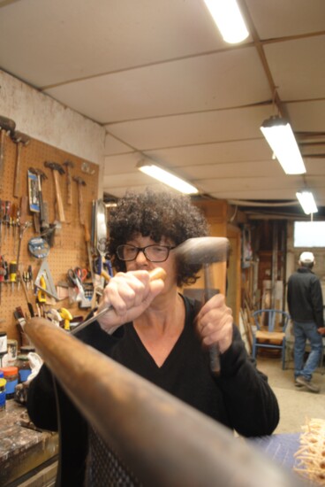 Eloa repairing a rattan backed chair. 