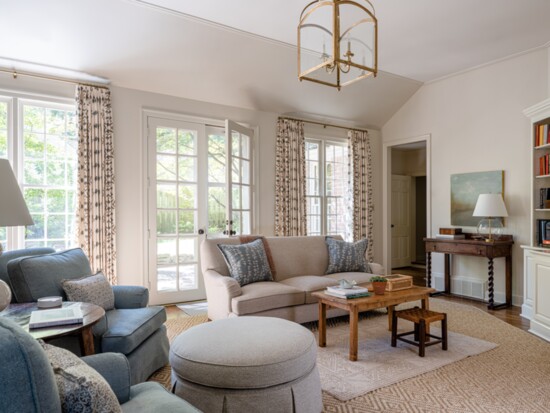 A mix of antique furnishings and clean upholstery grounds the space.