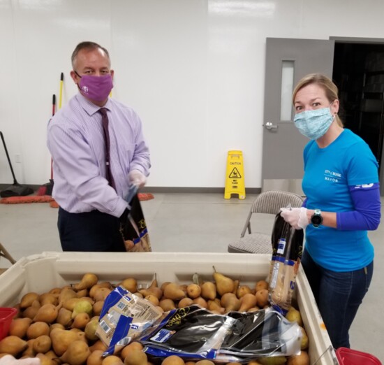 Meridian and Boise mayors repacking pears at the Meridian Idaho Foodbank facility at the end of 2020.