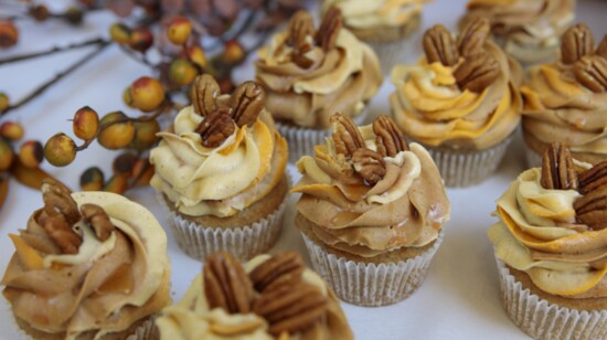 These spice cupcakes  are crowned with pumpkin spice icing and topped with pecans and drizzled with maple syrup.