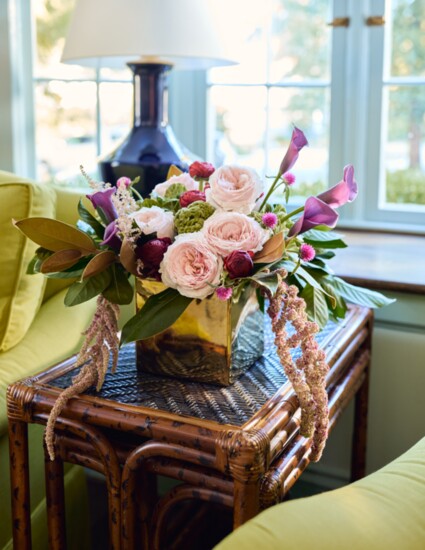 Gold ceramic square with magnolia greens, kale and green coxcomb to set off pink garden roses and astilbe, purple calla lilies, red ranunculus, and hot pink 