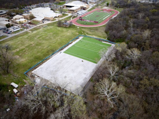 Workers lay turf on a new field hockey and soccer field, and the new field is one of the biggest investments into women’s athletics in school history.