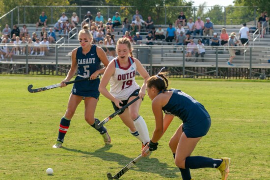 Claire Winton angles her way between two Casady School field hockey players during this year’s rivalry game.
